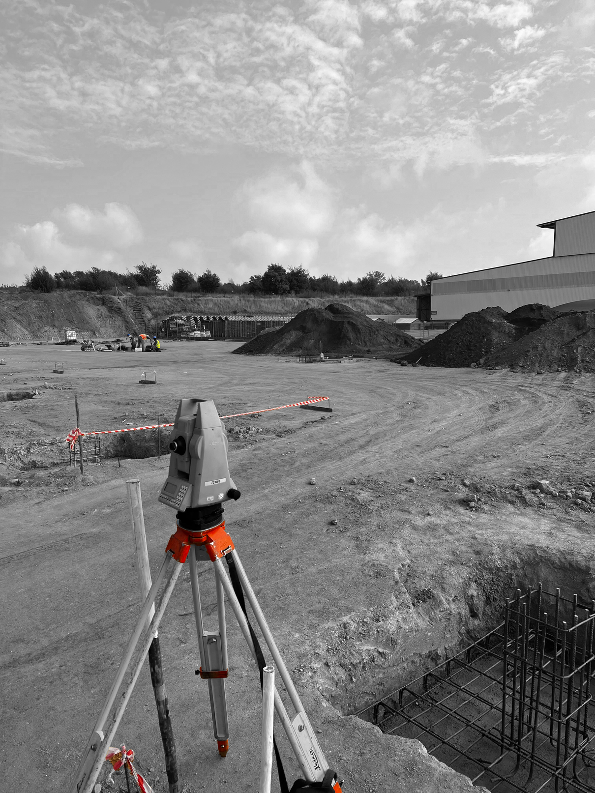 Surveyor total station in action setting out structural column bases during a commercial construction project